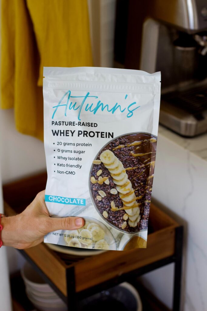 Autumn's Chocolate Protein Powder held out in the kitchen