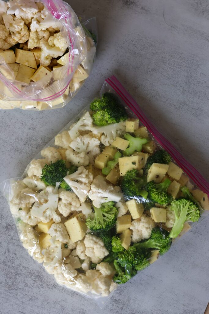 Chopped broccoli, sweet potato and cauliflower with olive oil stored in a gallon sized plastic bag