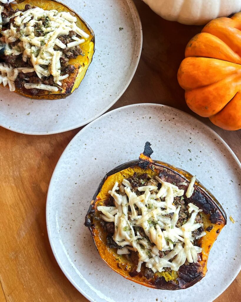ground beef stuffed acorn squash with pesto on a plate