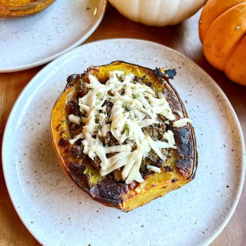 ground beef stuffed acorn squash with pesto on a plate