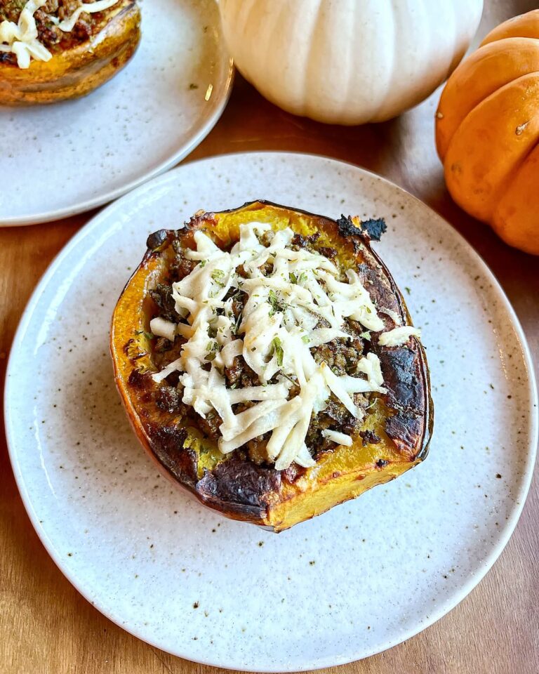 ground beef stuffed acorn squash with pesto on a plate