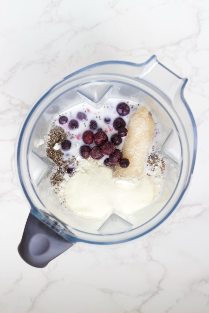 blueberry protein shake in a blender before it's blended