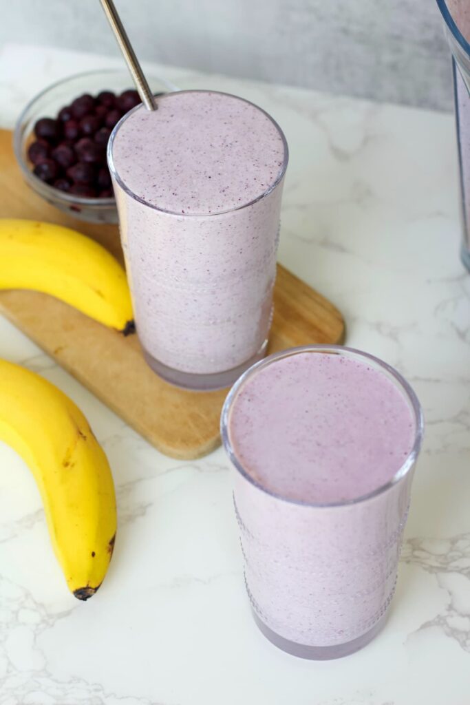 blueberry protein shake to glasses and a banana