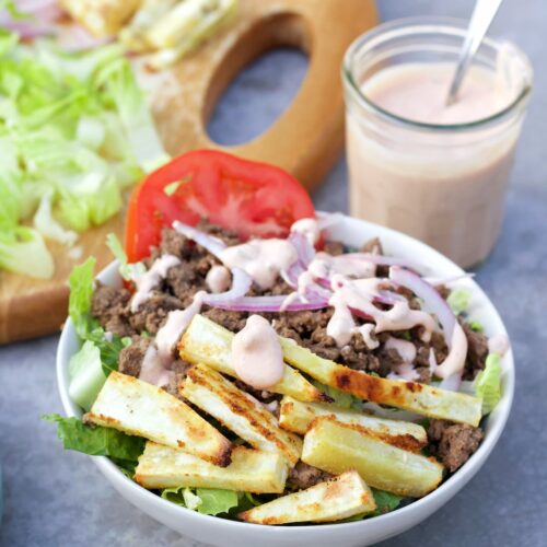 healthy burger bowl recipe in a bowl with sauce in the background
