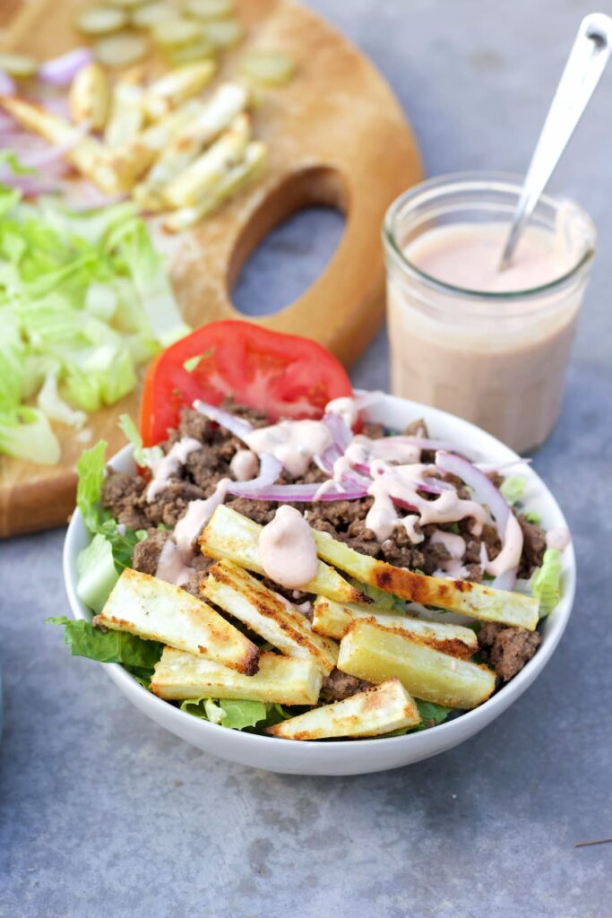 healthy burger bowl recipe in a bowl with sauce in the background