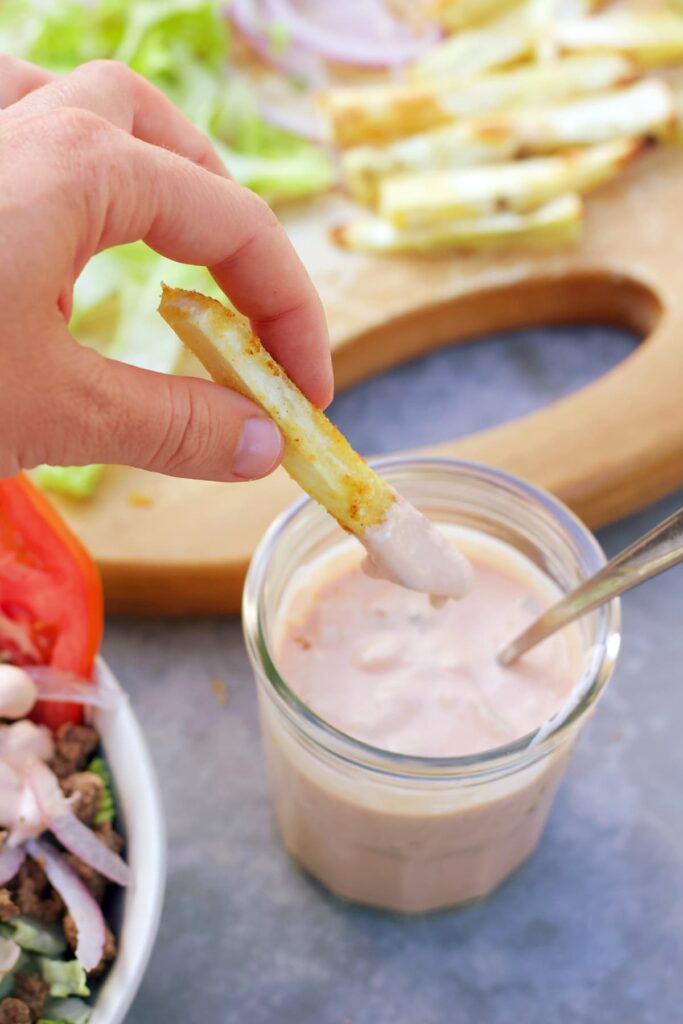 healthy burger sauce with a sweet potato fry dipping into it