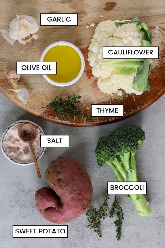 ingredients for garlic roasted fall vegetables including garlic, olive oil, cauliflower, thyme, salt and broccoli