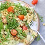 high protein pesto pasta salad with a fork in the plate