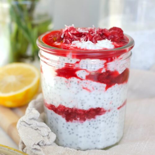 raspberry chia pudding in a mason jar with a lemon