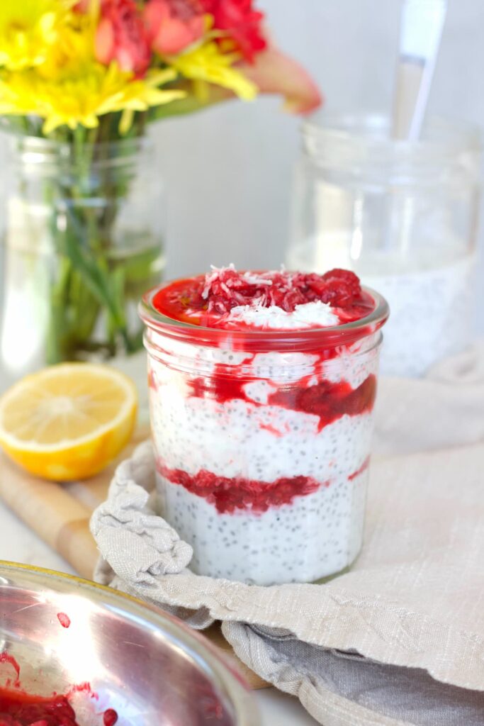 raspberry chia pudding in a mason jar with a lemon