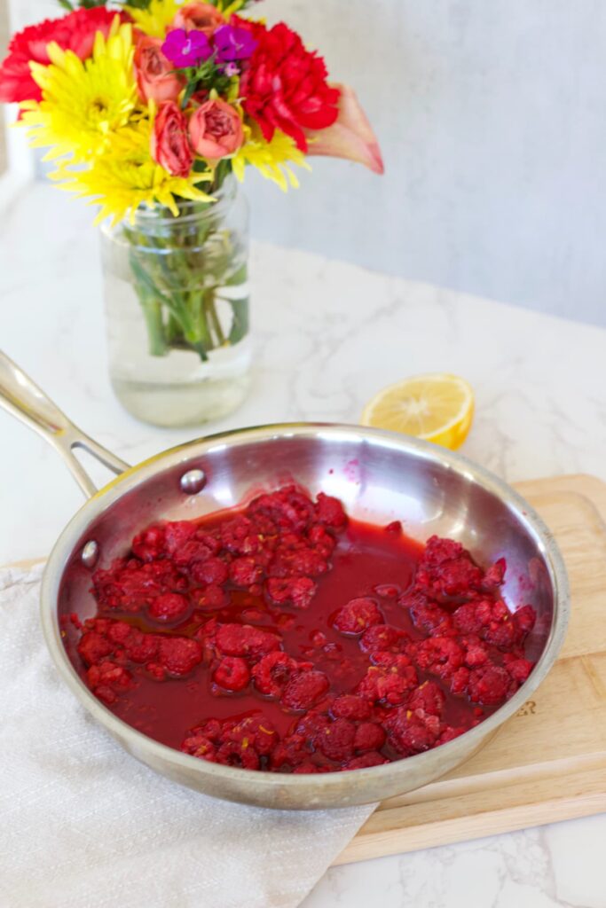 raspberry compote in a skillet with a lemon