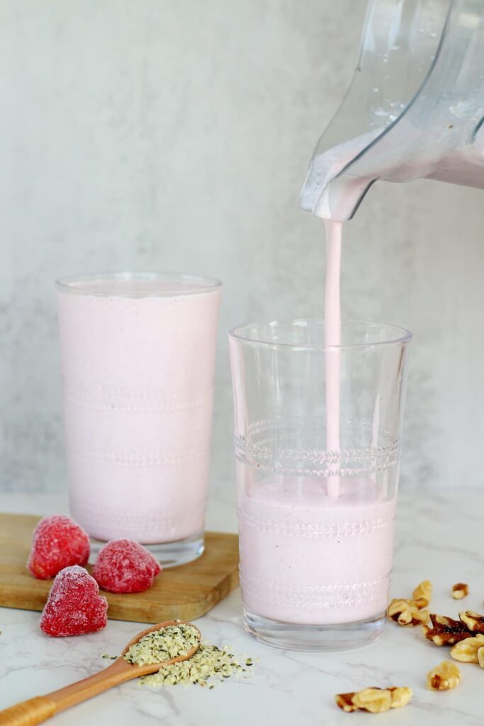 strawberry cottage cheese smoothie being poured into a glass