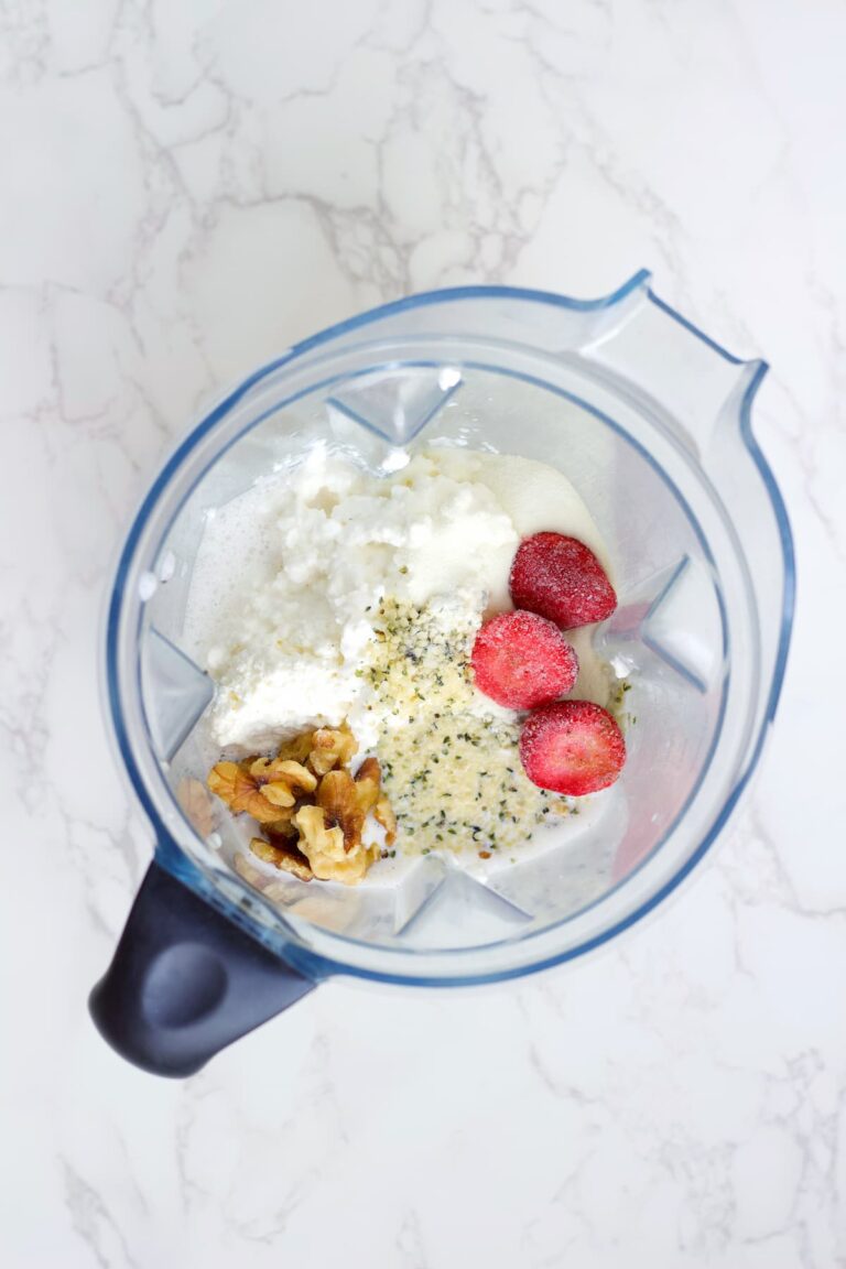 strawberry cottage cheese smoothie ingredients in a blender before it's blended