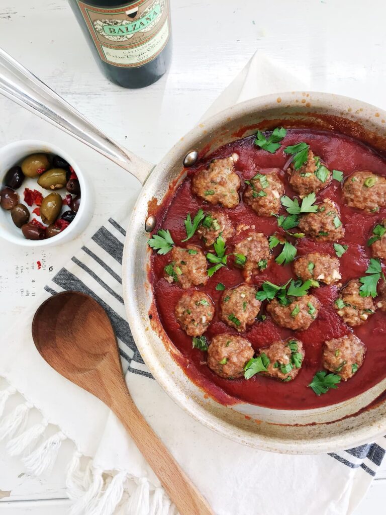 meatballs in a tomato sauce with a wooden spoon
