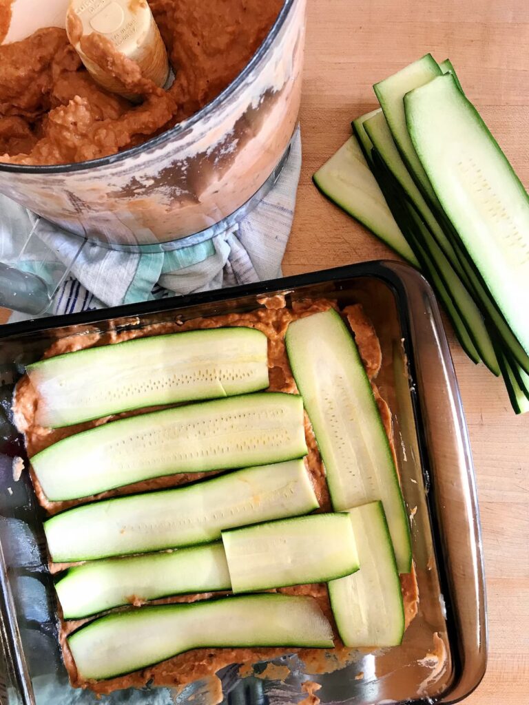 low carb zucchini lasagna being made with sliced zucchini