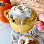 pumpkin spice mug cake in a mug with whipped cream topping