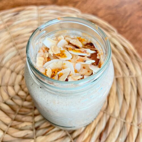 snickerdoodle protein smoothie in a glass with coconut flakes topping