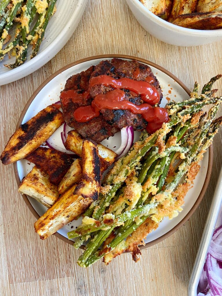 burgers without a bun paired with sweet potato fries and asparagus
