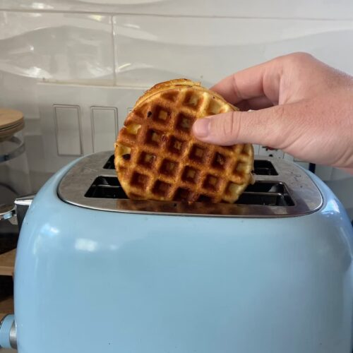 chocolate chip protein waffles being put into a toaster