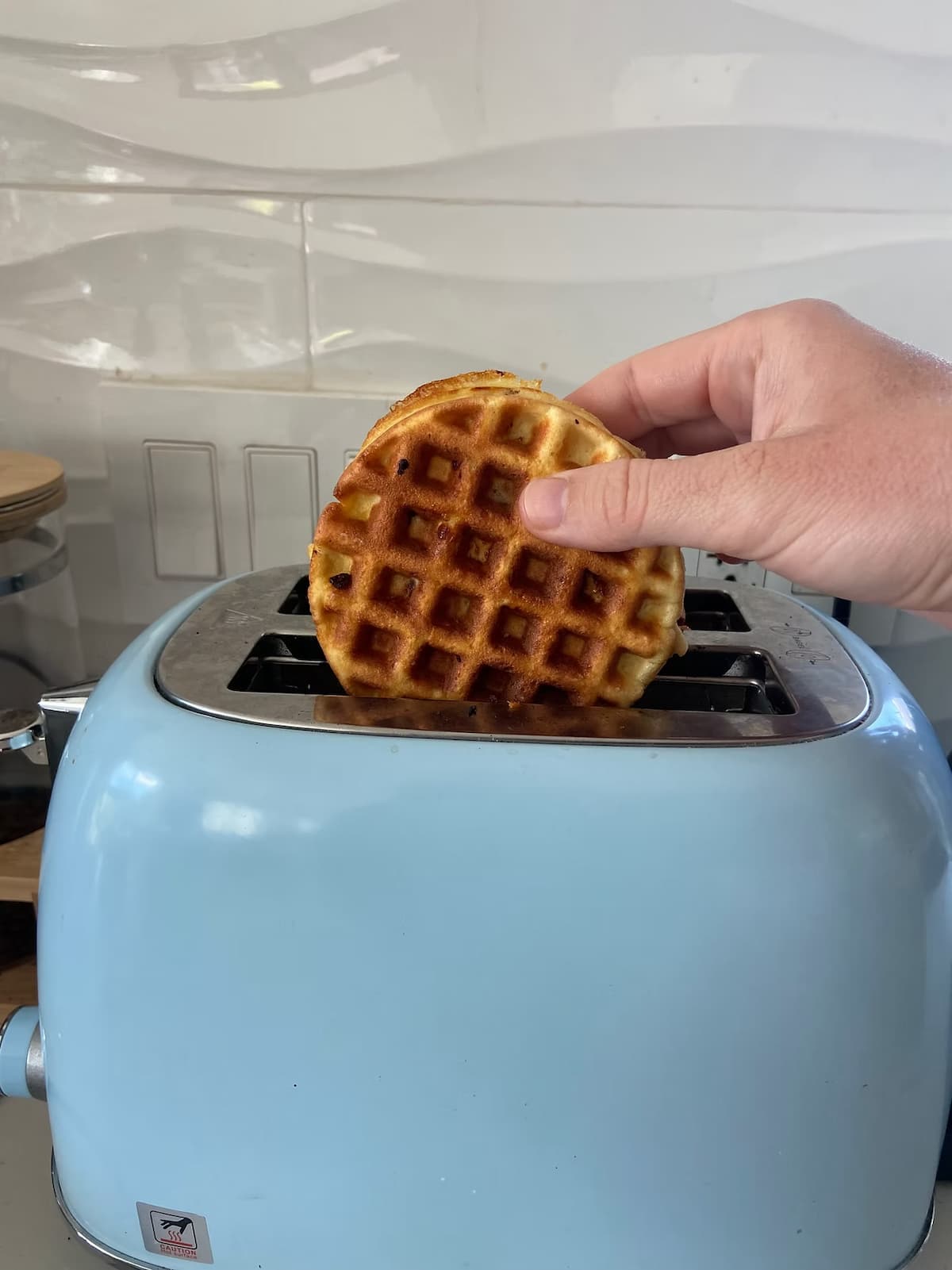 chocolate chip protein waffles being put into a toaster