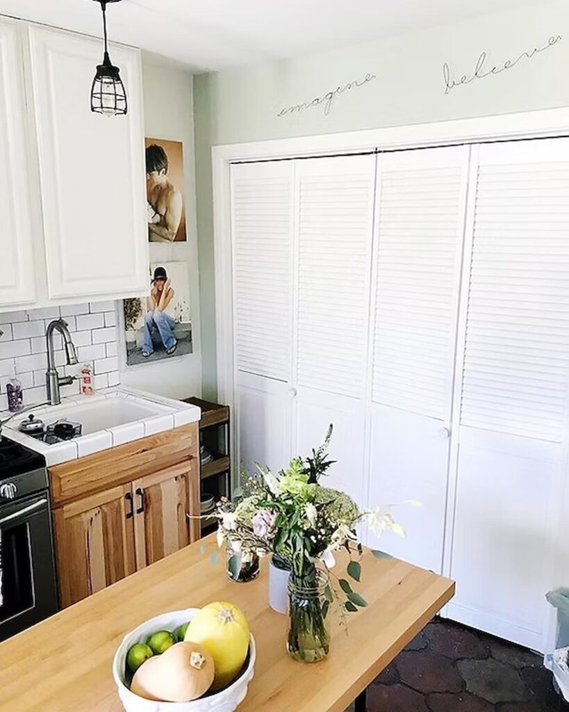 clean kitchen with flowers and a bowl of veggies