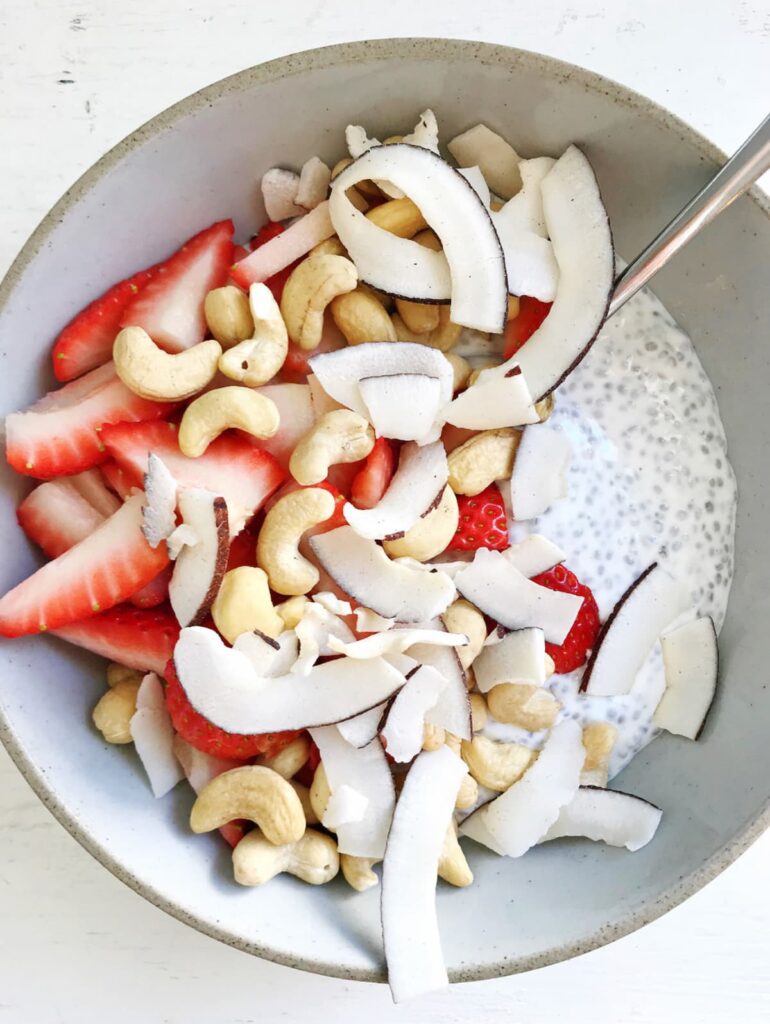 chia pudding with coconut flakes, cashews and strawberries