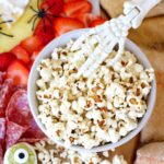 healthy popcorn in a bowl with a halloween skeleton hand in it