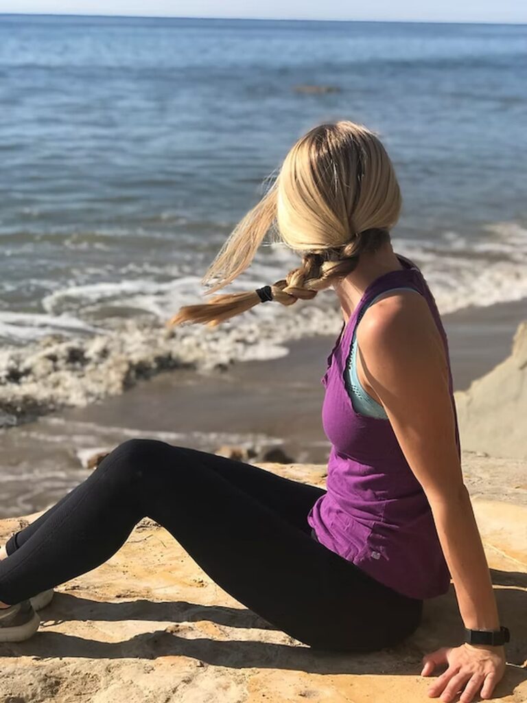 woman sitting on a rock at the beach