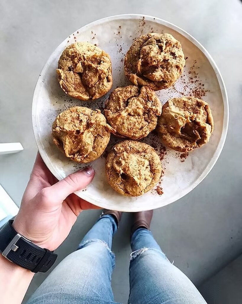 cinnamon peanut butter muffins on a plate with cinnamon sprinkled