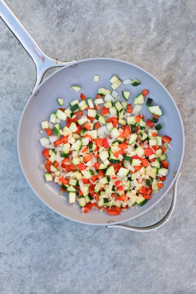 zucchini, bell pepper and onions in a sauté pan