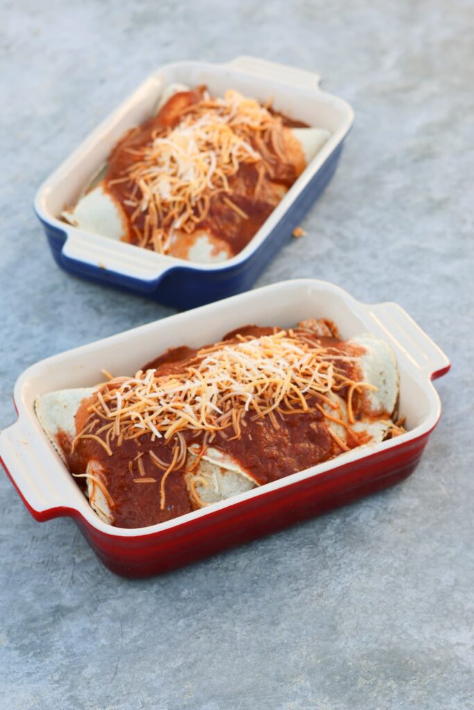 healthy chicken enchiladas in individual ceramic baking dishes before being baked