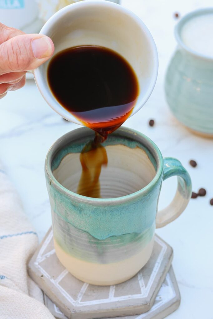 espresso shot being poured into a mug