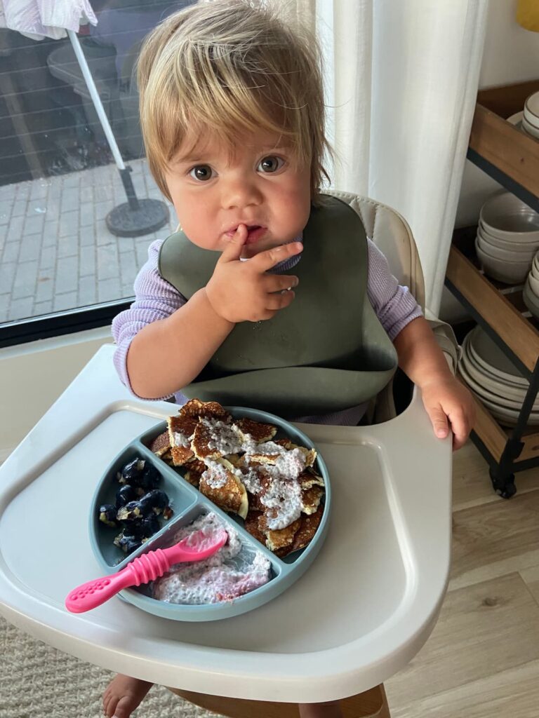 toddler girl eating breakfast with protein pancakes and chia pudding