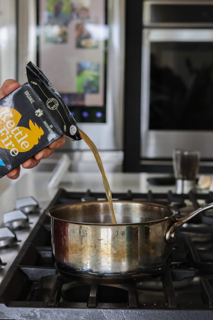bone broth being poured into a pot