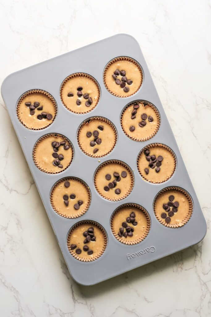 chocolate chip protein muffins in a muffin tin before baking