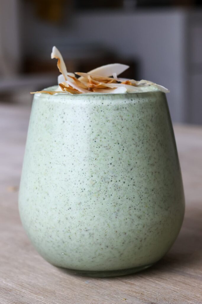 green protein smoothie with toasted coconut flakes topping