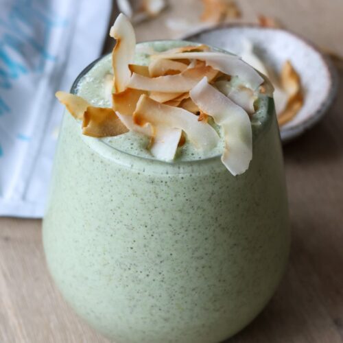 green protein smoothie with toasted coconut flakes topping