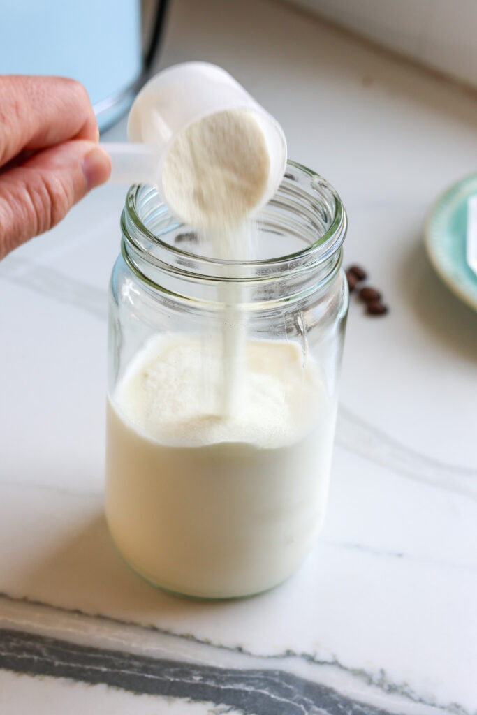 pouring protein powder into milk