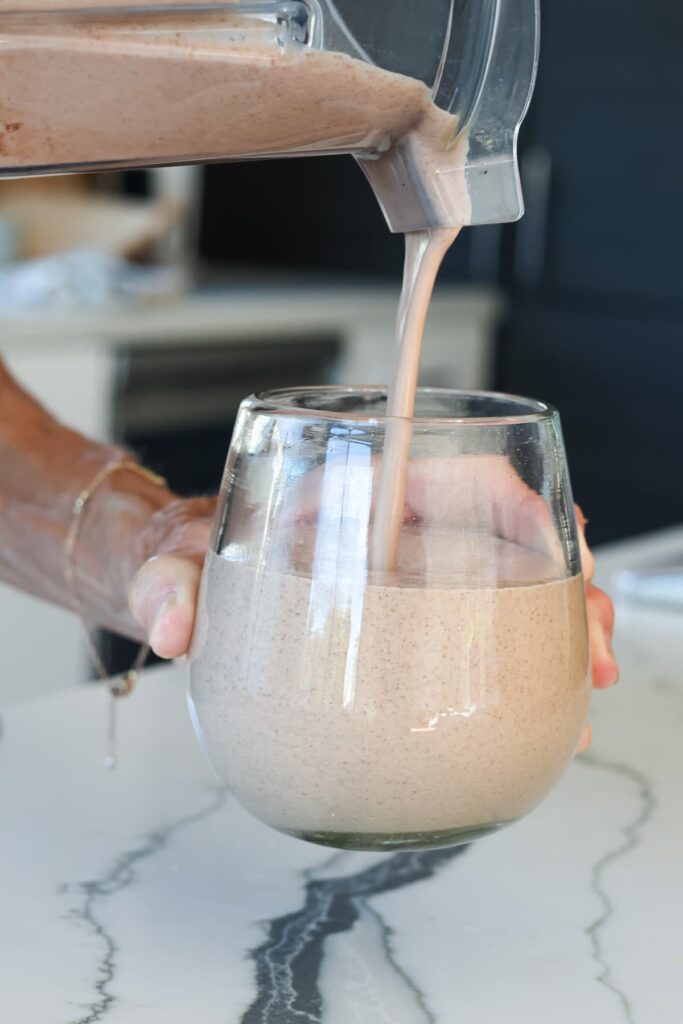 chocolate protein shake recipe being poured into a glass