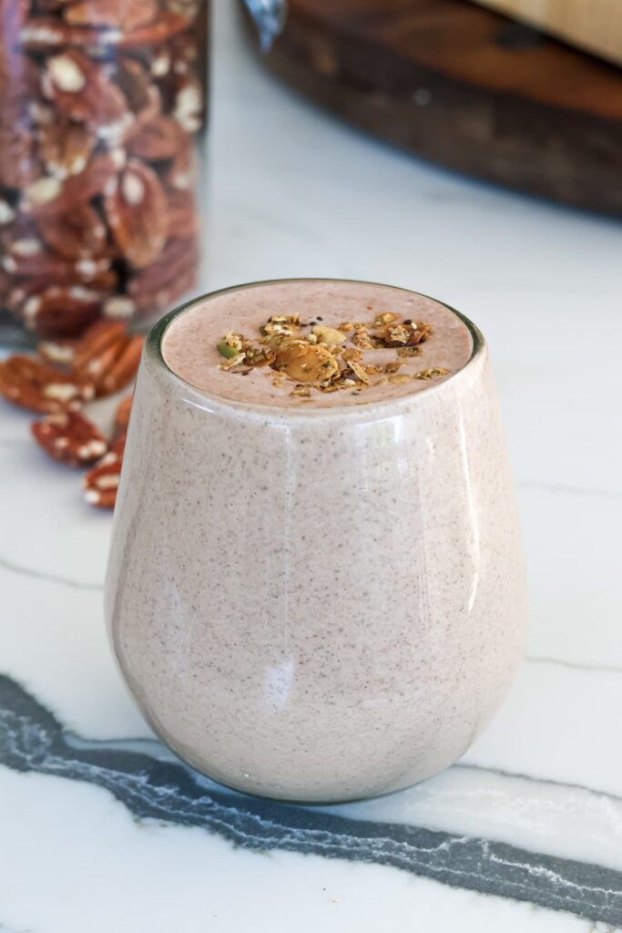 chocolate protein shake in a glass with toppings