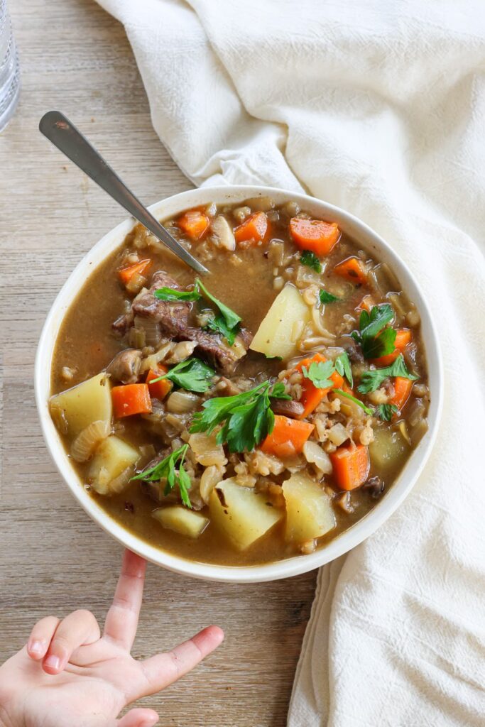 uber cozy beef stew with a toddler reaching for it